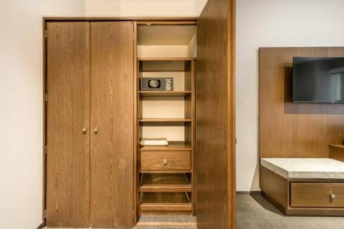 a wooden cabinet with a tv in a room at Antigua Hotel Boutique in Mexico City
