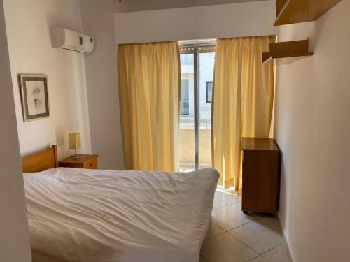een slaapkamer met een bed en een raam bij 1 bedroom flat 200m from the beach in germasogia tourist area in Limassol