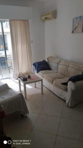 een woonkamer met een bank en een salontafel bij 1 bedroom flat 200m from the beach in germasogia tourist area in Limassol