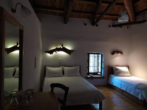 a bedroom with two beds and a table and a window at Sabouko Guest House in Vyzitsa