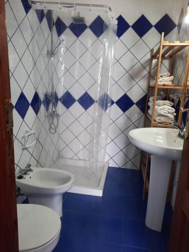 a blue and white bathroom with a toilet and a sink at Casita Miramar in El Paso