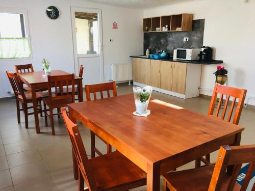 cocina y comedor con mesa de madera y sillas en Pensiunea La Bozi, en Utvin