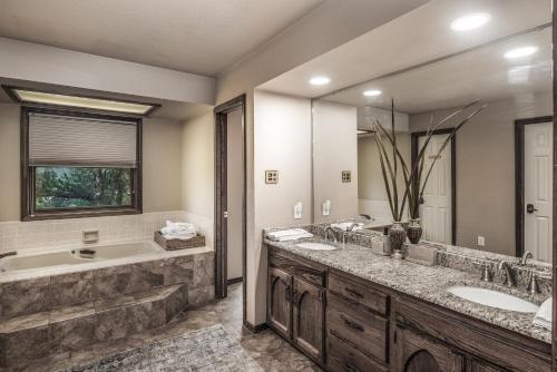 a bathroom with two sinks and a tub and a large mirror at White Mountain Chateau in Ruidoso