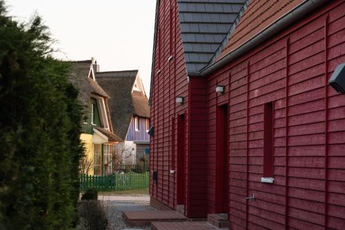 una casa roja con una pared de ladrillo rojo en Ferienwohnung Rote Kate, en Born