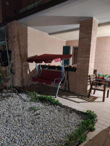 a patio with a table and a red umbrella at La Quercia Fiorita in Trivolzio