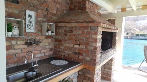 una cocina de ladrillo con fregadero y un horno de ladrillo en Una Luxury Home, en Bihać