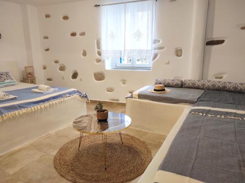 a room with two beds and a table at Villa Adriana in Parikia