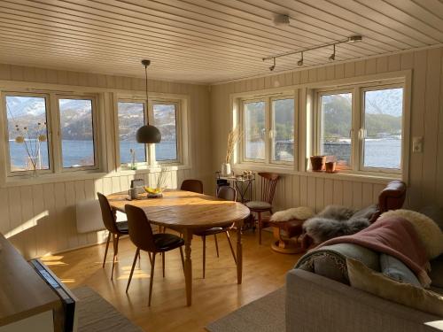 een woonkamer met een tafel, stoelen en ramen bij Wilderness House in Urda