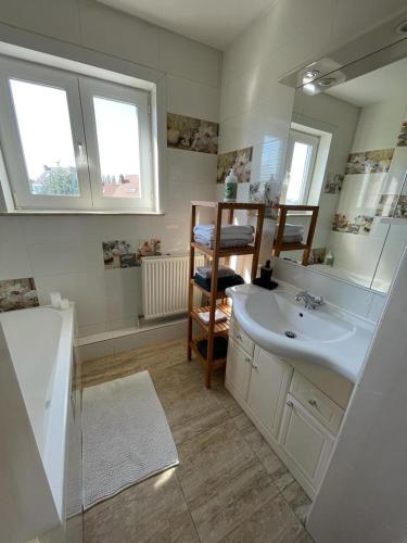 La salle de bains est pourvue d'un lavabo blanc et d'un miroir. dans l'établissement Appartement dans un beau quartier à Anderlecht, à Bruxelles