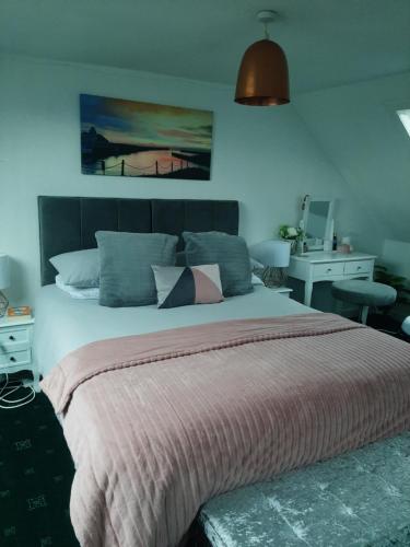 um quarto com uma cama grande e uma secretária em Stunning Riverside Town House with views Ayrshire em Girvan