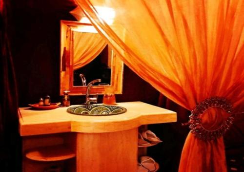 a bathroom with a sink and a mirror at Berber Camp in Merzouga