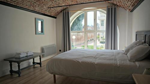 um quarto com uma cama e uma grande janela em Little Suite - Coline em Lille