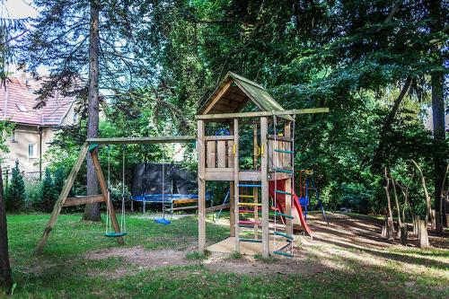 a wooden playground with a slide and a play structure at Pytloun Self Check-in Hotel Liberec in Liberec