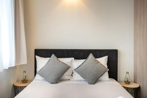 a bed with two pillows on top of it at White & Gray apartment in Rethymno