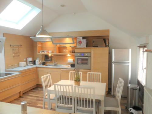 une cuisine avec une table et des chaises dans une cuisine dans l'établissement Maison de ville, fibre et Netflix, à Belfort