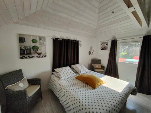 a bedroom with a bed and a chair in it at Gîte pause au jardin in Saint-Branchs