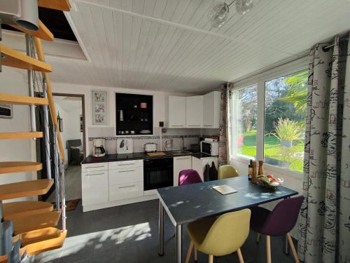 a kitchen with a table and chairs and a window at Gîte pause au jardin in Saint-Branchs