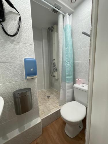 La petite salle de bains est pourvue d'une douche et de toilettes. dans l'établissement Hôtel Le Green, au Havre