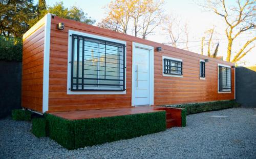 a tiny house with a porch and a door at Apart SmartBox in Campana