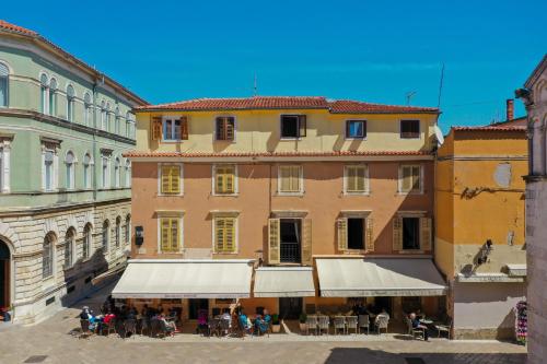 un grupo de personas sentadas fuera de un edificio en Luxury Rooms Contessa Vitali, en Zadar