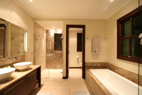 łazienka z 2 umywalkami, wanną i prysznicem w obiekcie Eden Island Maison 78 (Private Pool) w mieście Eden Island