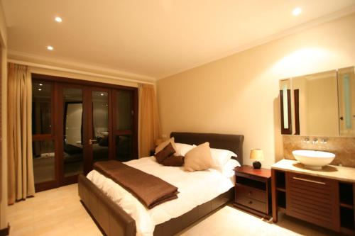 a bedroom with a large bed and a sink at Eden Island Maison 78 (Private Pool) in Eden Island