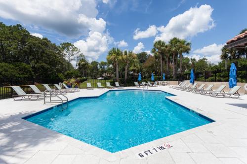 a swimming pool with lounge chairs at Surf Villa 626 in Ponte Vedra