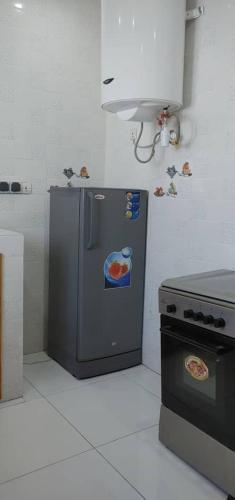 a kitchen with a small refrigerator and a stove at MBAO Sipres Appartement moderne bord de mer in Mbaw