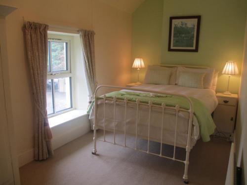 a bedroom with a bed and a window at Tralia Farmhouse Self Catering in Farranfore