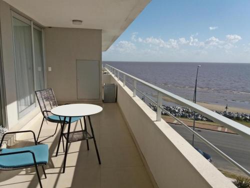 balcón con mesa, sillas y vistas al océano en Dos Orillas - Apartamento 510, en Colonia del Sacramento