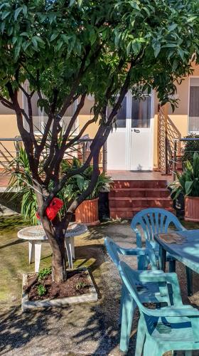 a tree with blue tables and chairs next to a tree at Berti Apartment in Vlorë