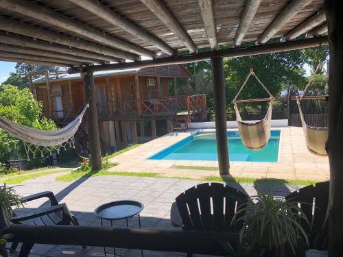 a patio with chairs and hammocks and a pool at Monoambiente Playa Nebel in Concordia