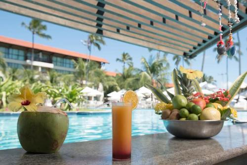 stół z miską owoców i szklanką soku w obiekcie Suíte na beira-mar do Resort Marulhos Muro Alto Porto Galinhas w mieście Porto de Galinhas