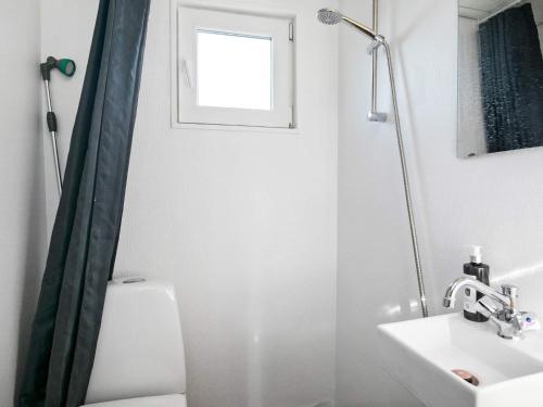 baño con aseo y lavabo y ventana en Holiday home Brovst XVII, en Brovst