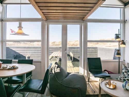 a room with a table and chairs and windows at 2 person holiday home in Brovst-By Traum in Brovst