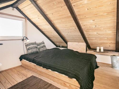 1 dormitorio con 1 cama en una habitación con techos de madera en Holiday home Brovst XVII, en Brovst