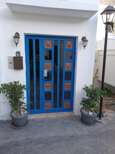 a blue door on a building with two potted plants at Lefteri's Rooms in Agia Galini