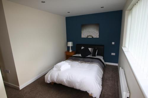 1 dormitorio con 1 cama con pared azul en Broadwell Guest House, en Meriden