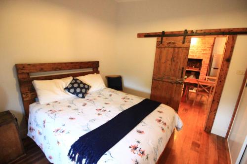 a bedroom with a bed and a wooden door at The Cottage in Bairnsdale