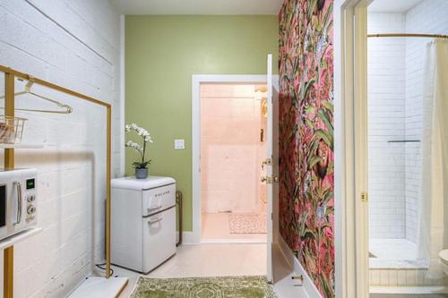 a bathroom with a shower and a door leading to a kitchen at The Oleander Hotel Room 7 in Galveston