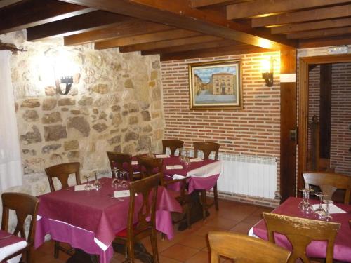 サント・ドミンゴ・デ・シロスにあるHotel Rural Villa de Silosの紫のテーブルクロスを使用したテーブルと椅子付きのレストラン