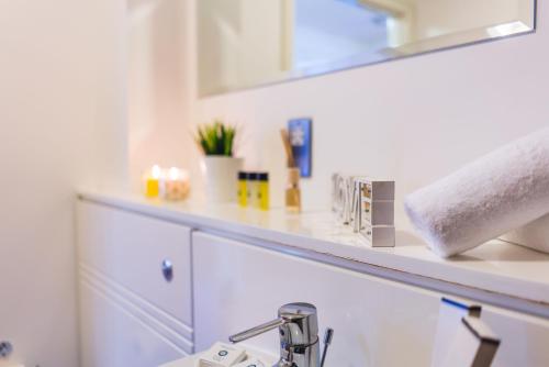 Inners City Apartments -On Suites في برمنغهام: منضدة الحمام مع الحوض والمرآة