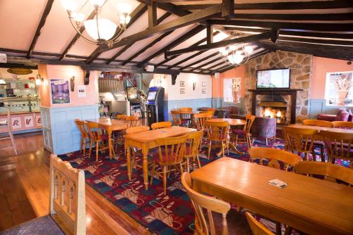 a restaurant with tables and chairs and a fireplace at The Highwayman Inn in Shepton Mallet