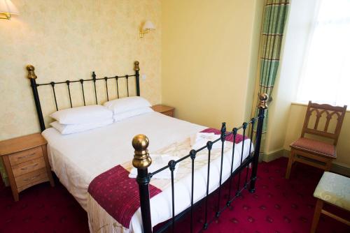 a bedroom with a large bed and a chair at The Highwayman Inn in Shepton Mallet