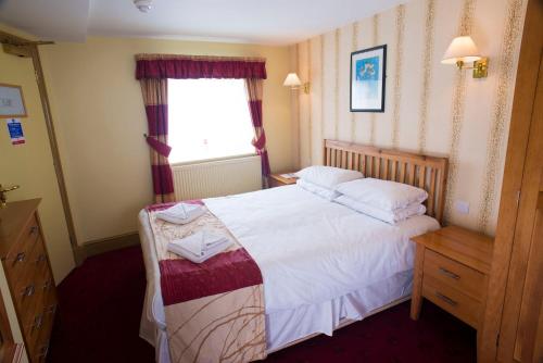 - une chambre avec un grand lit et une fenêtre dans l'établissement The Highwayman Inn, à Shepton Mallet