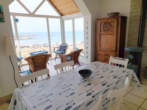 une salle à manger avec une table et une vue sur l'océan dans l'établissement Fisherman's House in Brittany by the Sea, à Plouescat