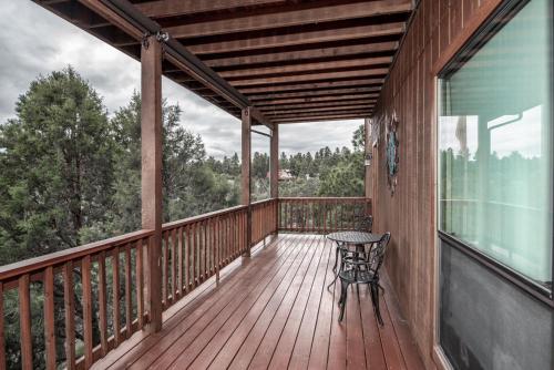 a wooden deck with a table and a bench on it at Robins Nest in Ruidoso