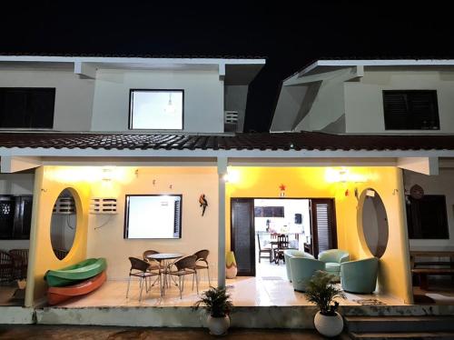 Cette maison dispose d'une terrasse avec une table et des chaises. dans l'établissement CASA DUPLEX em CONDOMÍNIO à beira do RIO PREGUIÇAS, à Barreirinhas