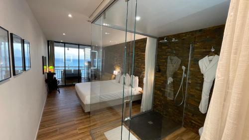 una camera da letto con un letto e una doccia in vetro di Vue Mer & Rocher - Okavango Blue Studio a Le Diamant
