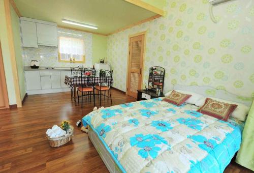 a bedroom with a large bed and a kitchen at Prime Pension in Yangyang
